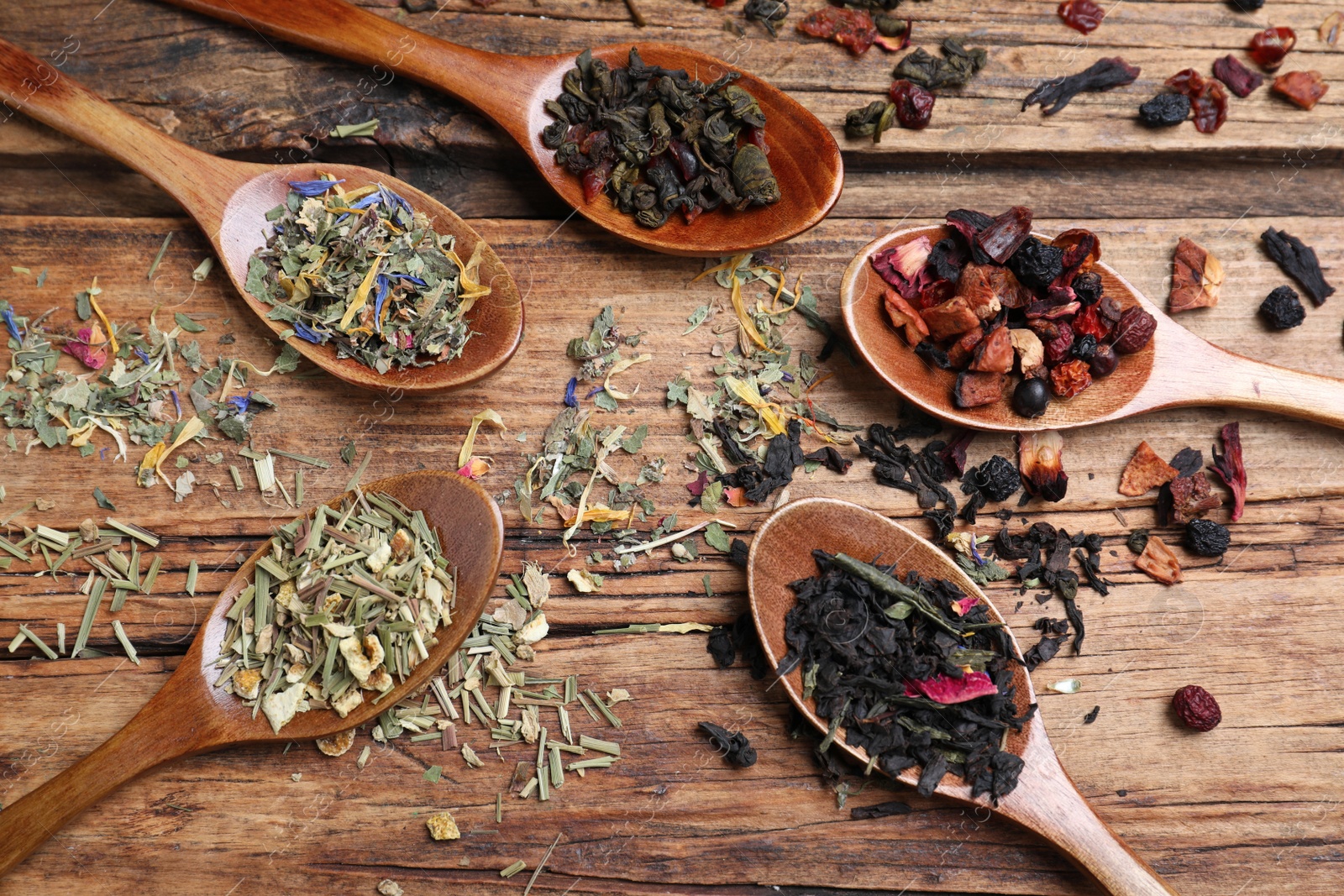 Photo of Flat lay composition with different teas and spoons on wooden table