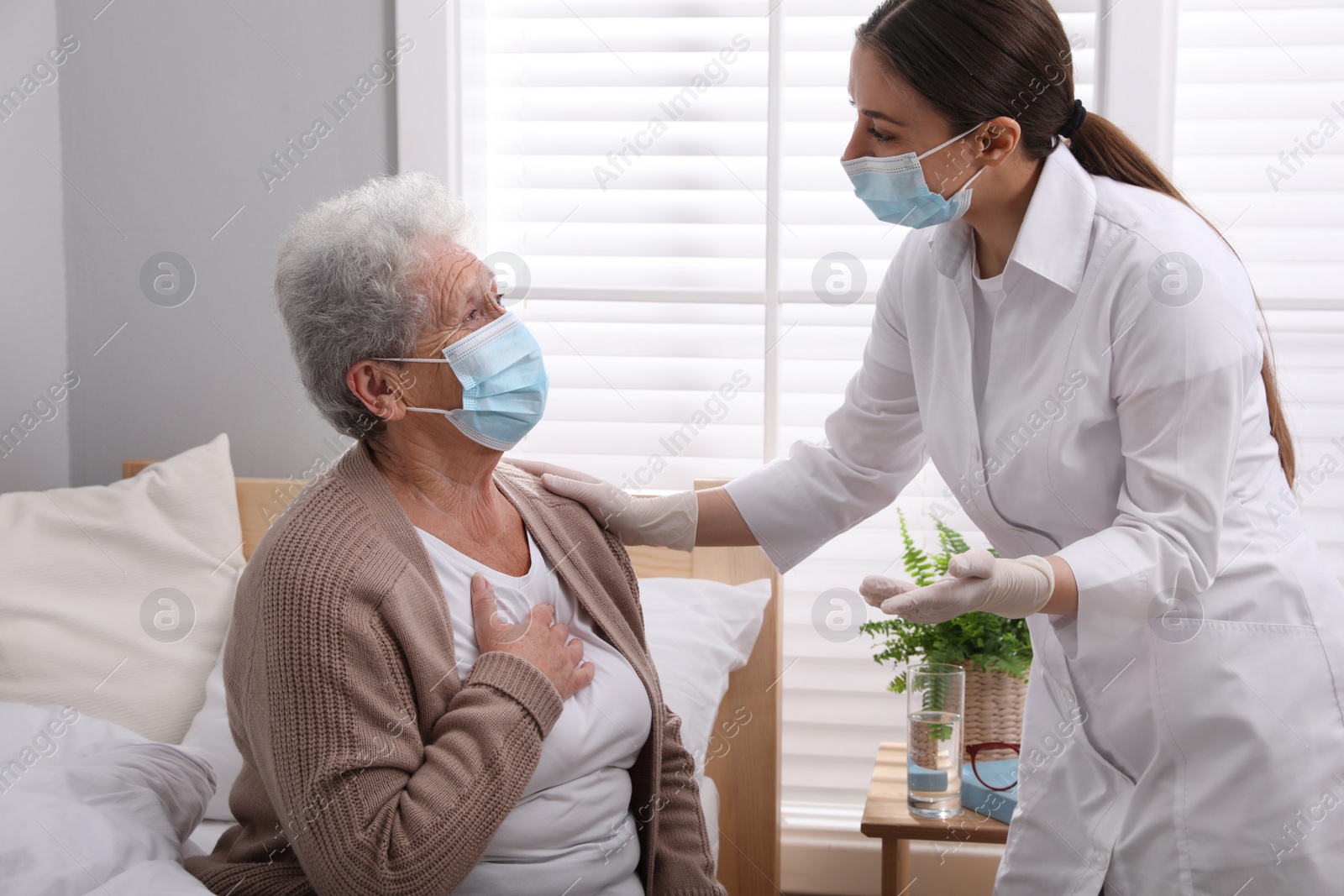 Photo of Doctor taking care of senior woman with protective mask at nursing home