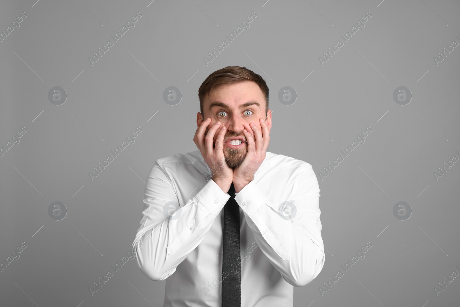 Photo of Portrait of emotional businessman on light grey background. Personality concept