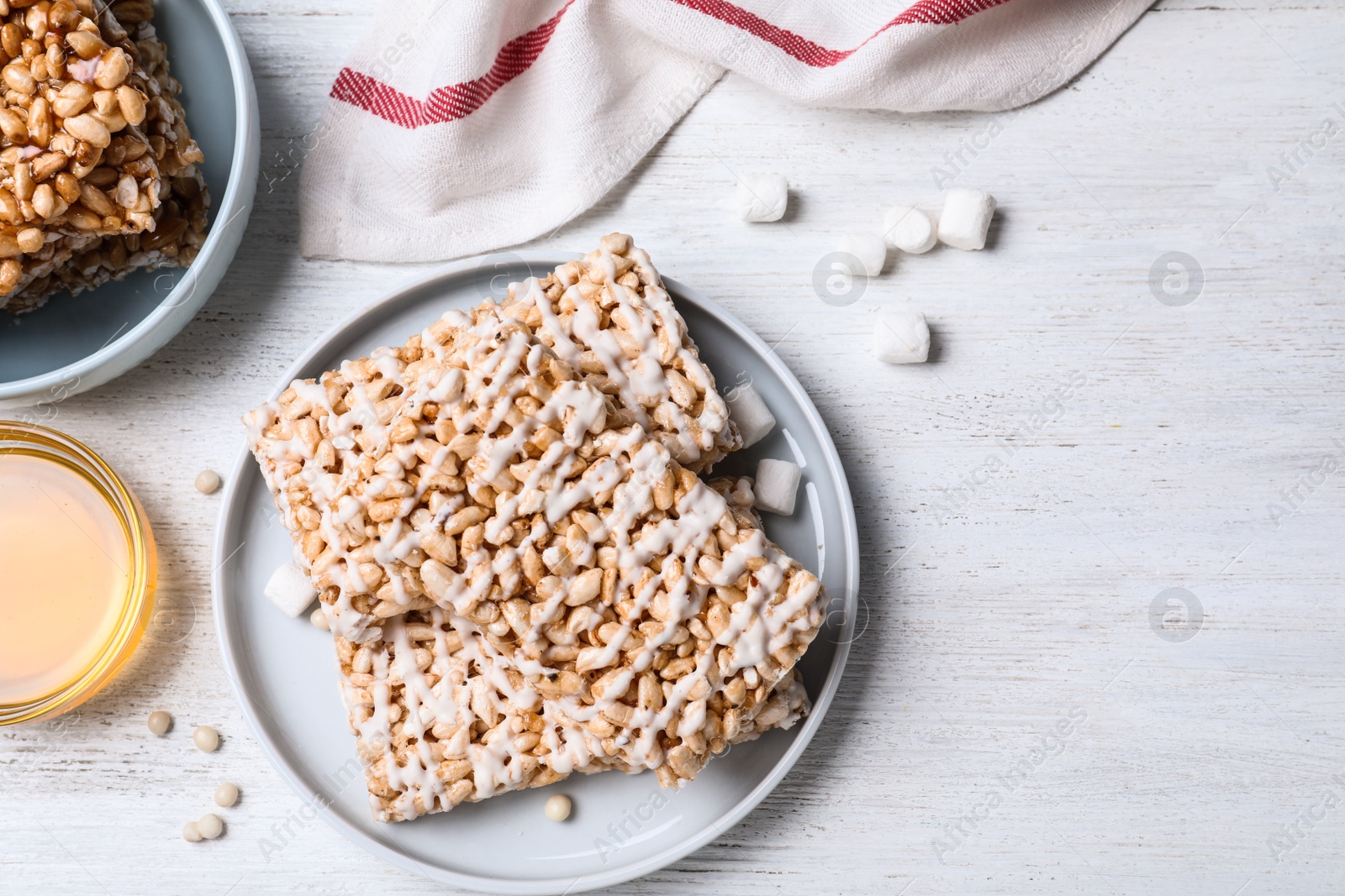 Photo of Delicious rice crispy treats on white wooden table, flat lay