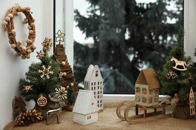 Photo of Many beautiful Christmas decorations and small fir trees on window sill indoors