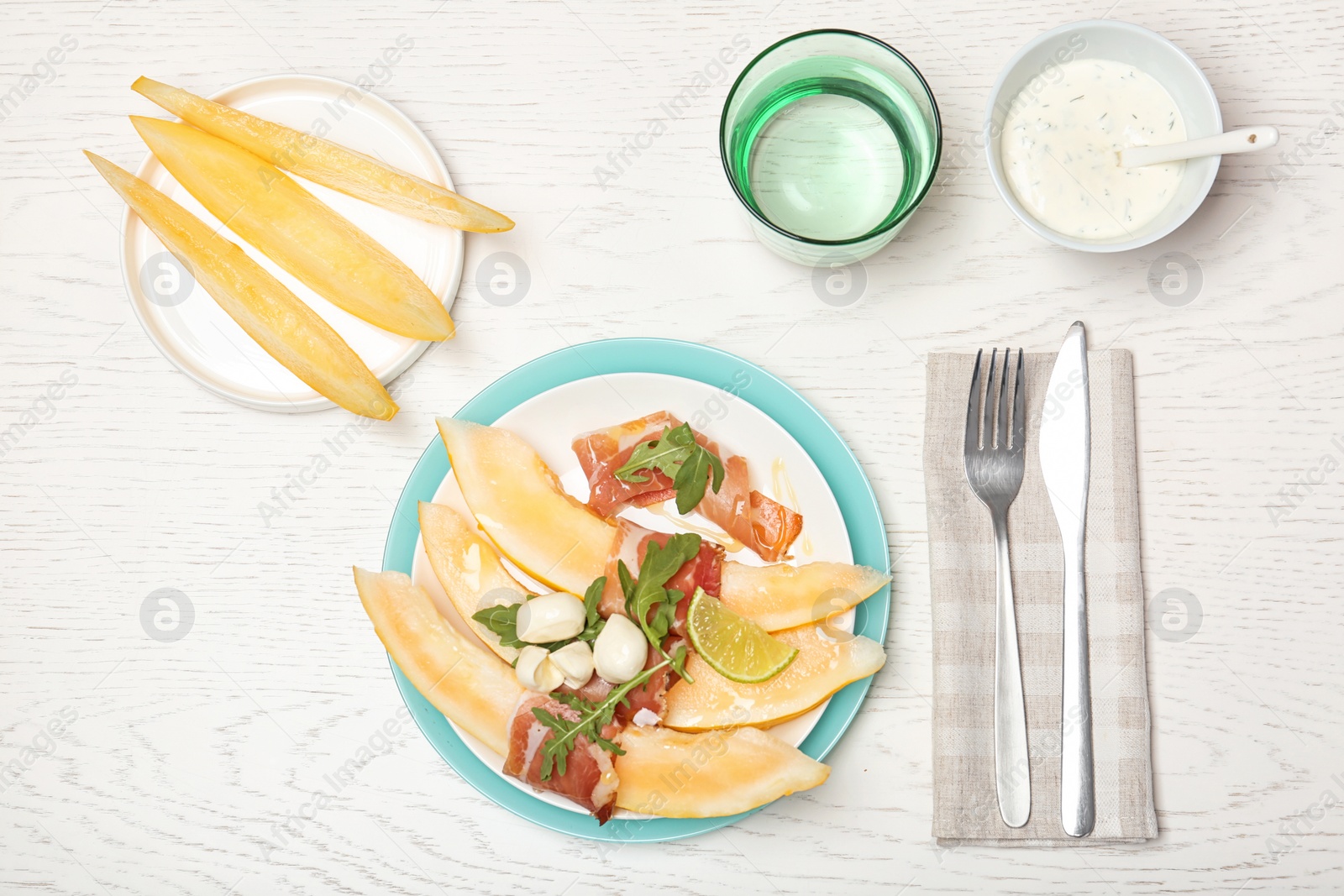 Photo of Flat lay composition with melon and prosciutto appetizer served on light table