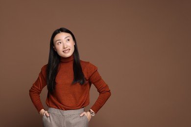 Photo of Portrait of smiling woman on brown background. Space for text