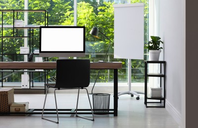 Comfortable workplace with modern computer and stylish furniture in room. Interior design
