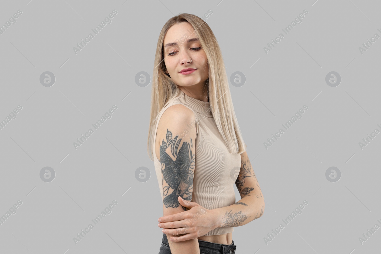 Photo of Portrait of beautiful tattooed woman on gray background