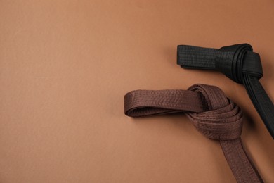 Photo of Karate belts on brown background, flat lay. Space for text