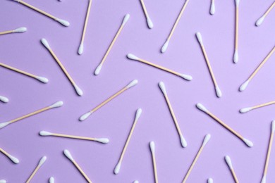 Photo of Many cotton buds on violet background, flat lay