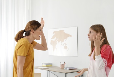 Photo of Mother scolding her teenager daughter at home