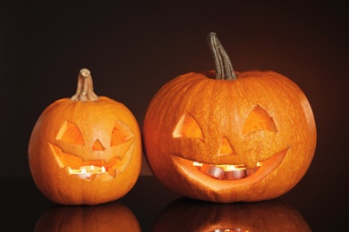 Photo of Halloween pumpkin heads. Glowing jack lanterns on dark background