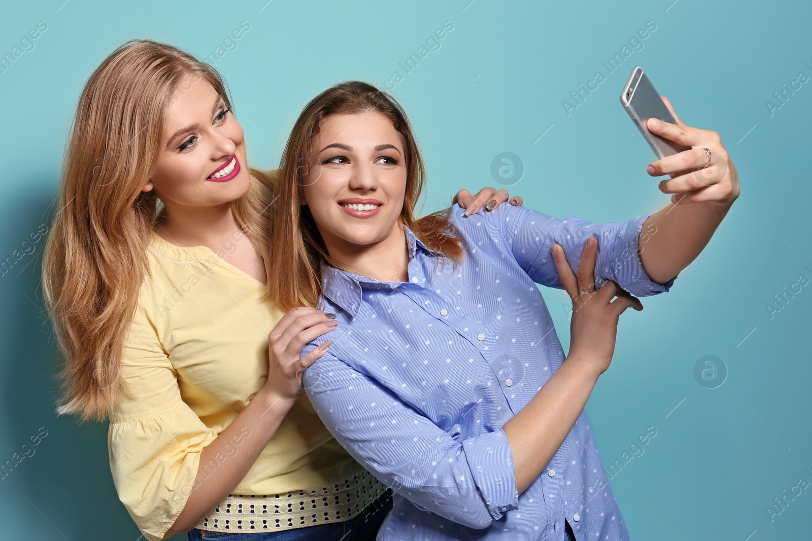 Photo of Attractive young women taking selfie on color background