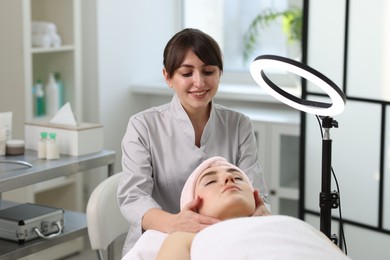 Photo of Cosmetologist making face massage to client in clinic