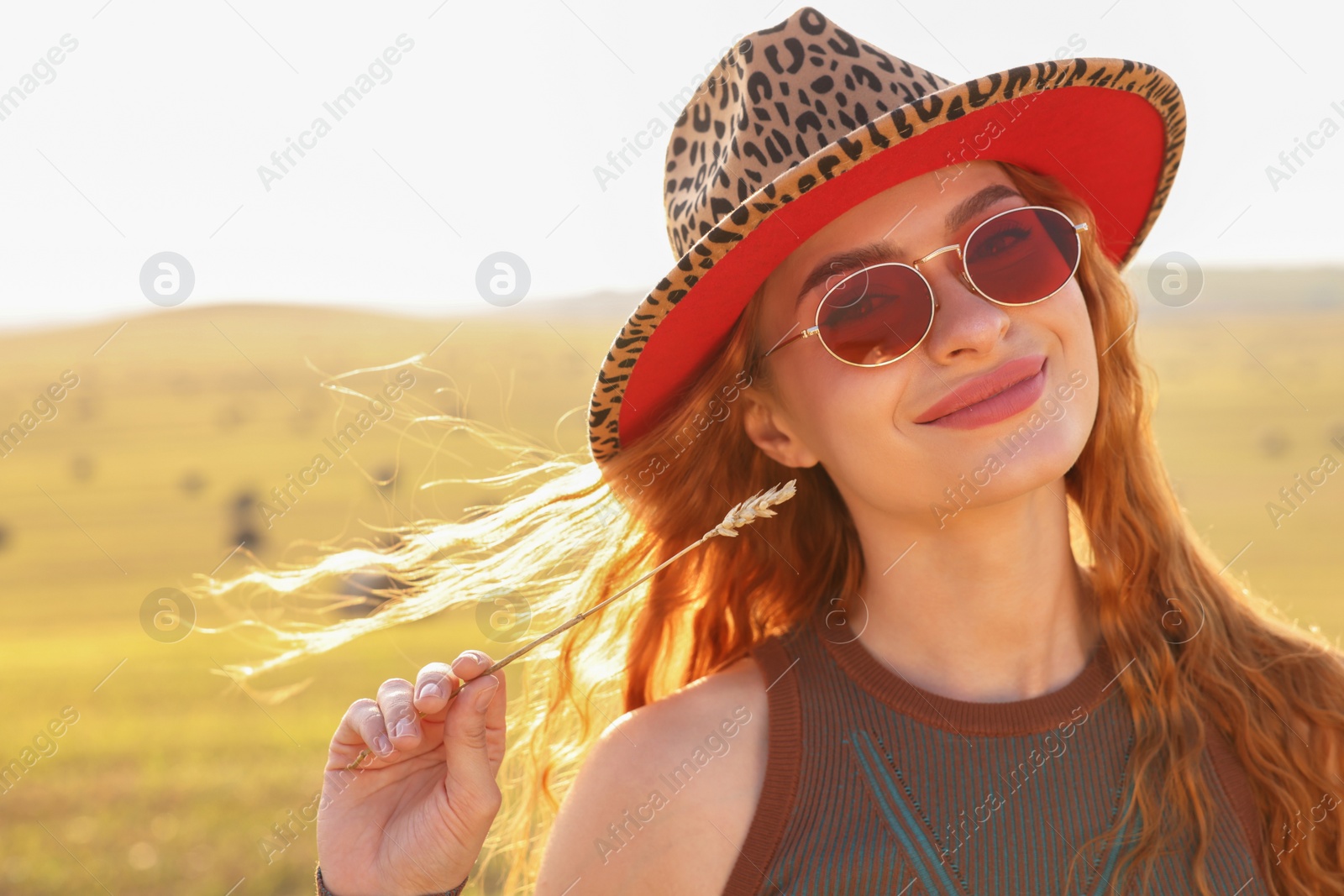 Photo of Beautiful happy hippie woman with spikelet in field, space for text