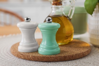 Salt and pepper shakers and bottle of oil on table