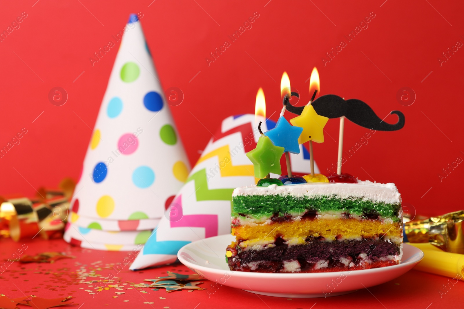Photo of Piece of birthday cake with candles on red background, space for text