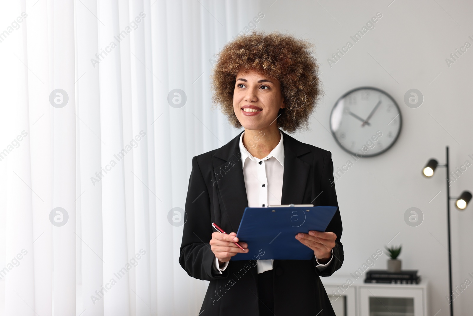 Photo of Happy notary with clipboard and pen in office