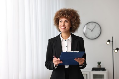 Photo of Happy notary with clipboard and pen in office