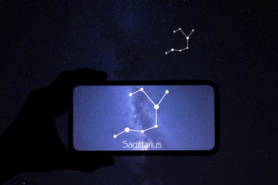 Image of Man using stargazing app on his phone at night, closeup. Identified stick figure pattern of Sagittarius (Archer) constellation on device screen