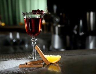 Fresh red cinnamon whiskey alcoholic cocktail on bar counter. Space for text