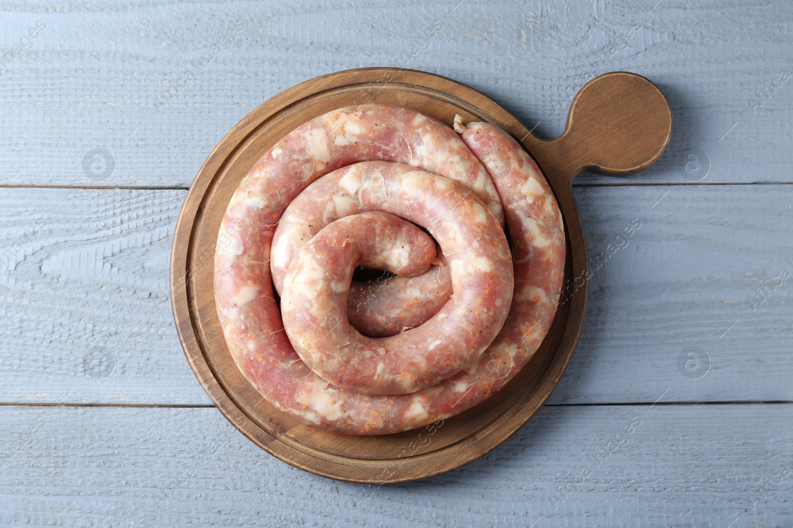 Photo of Homemade sausages on light grey wooden table, top view