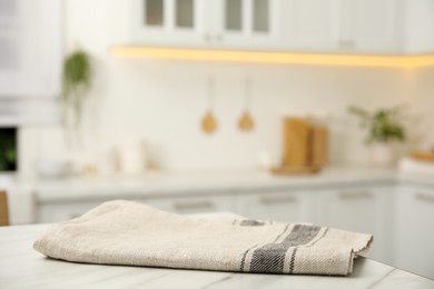 Photo of Clean towel on white marble table in kitchen