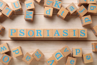 Word Psoriasis made of cubes with letters on white wooden table, flat lay