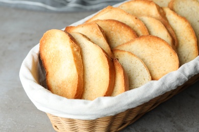 Photo of Slices of toasted bread in basket on grey table