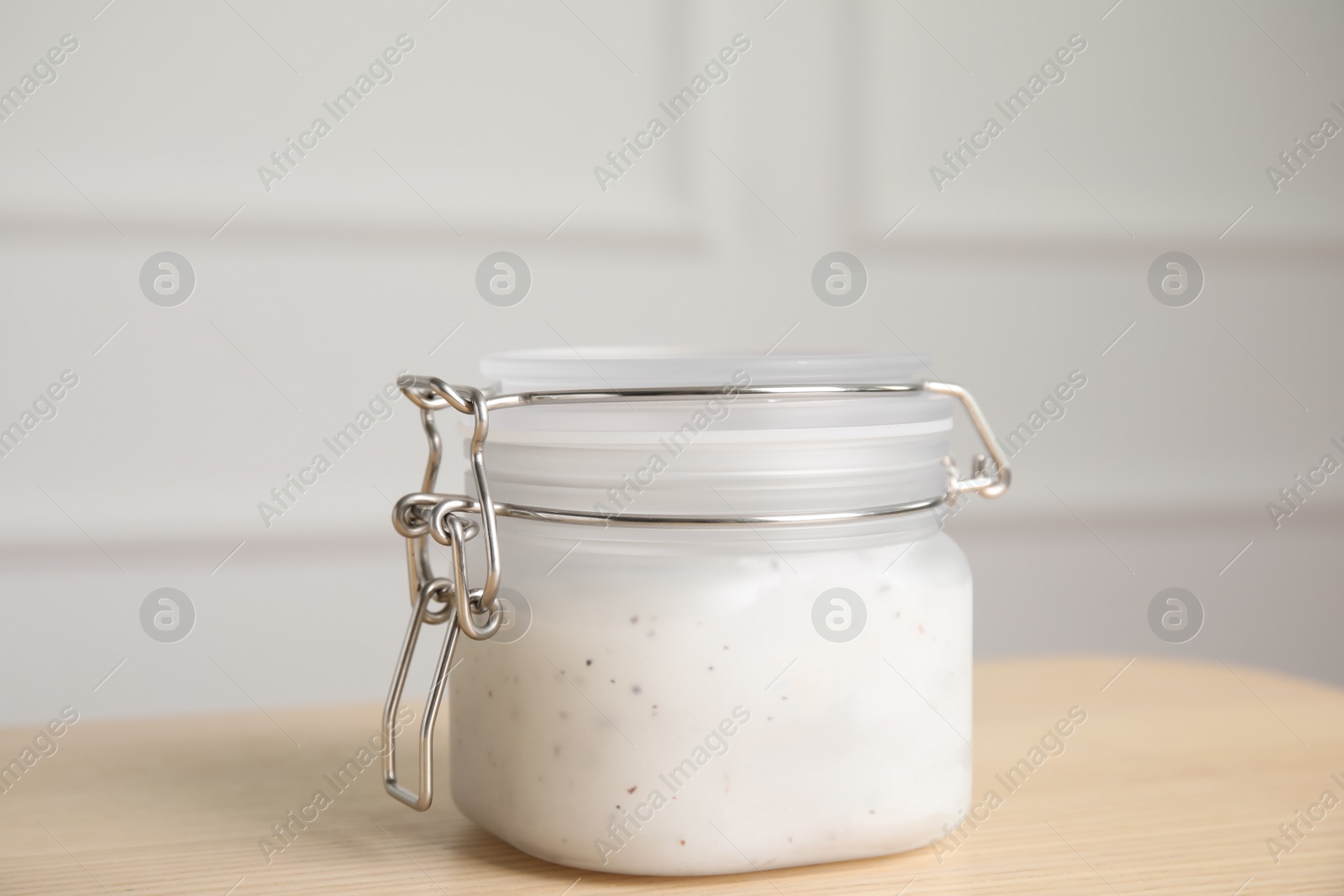 Photo of Jar of salt scrub on wooden table