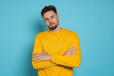 Photo of Handsome man in yellow sweatshirt on light blue background