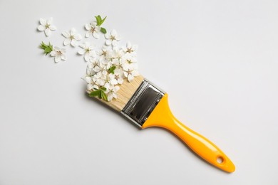 Photo of Paint brush and beautiful flowers on white background, flat lay