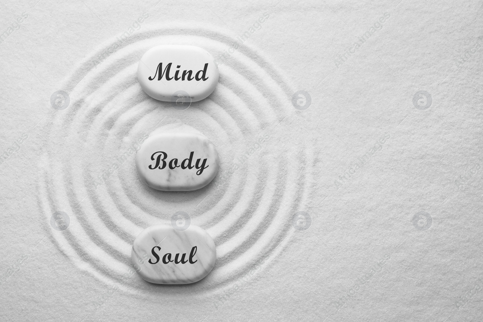 Image of Stones with words Mind, Body, Soul on sand, flat lay. Zen and harmony 