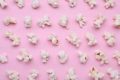 Tasty popcorn on pink background, flat lay