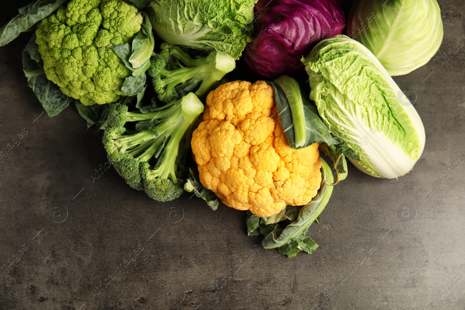 Photo of Different fresh cabbages on table, top view. Healthy food