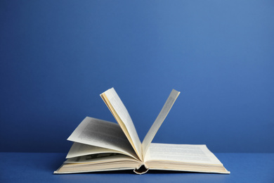 Open old hardcover book on blue background