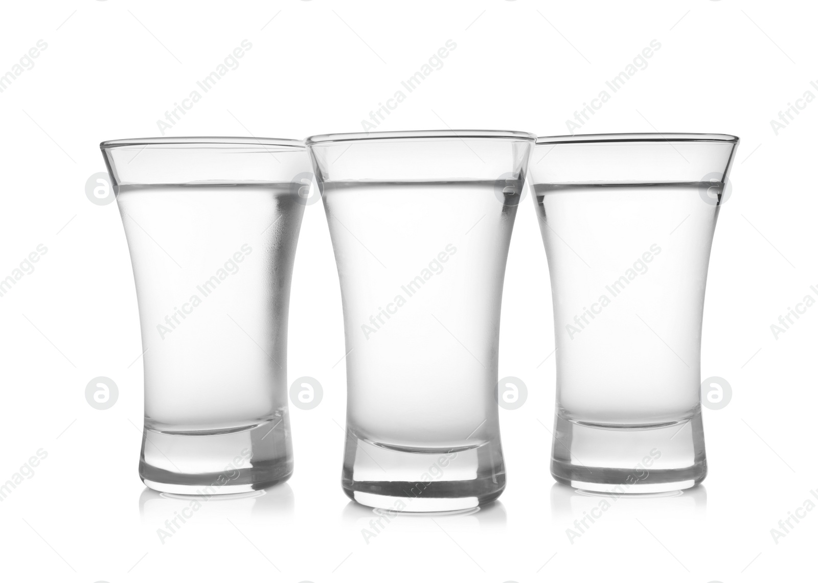 Photo of Cold vodka in shot glasses on white background