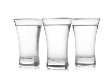 Photo of Cold vodka in shot glasses on white background