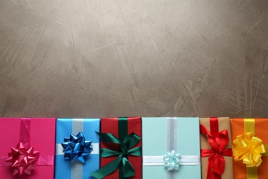 Photo of Many colorful gift boxes on grey table, flat lay. Space for text