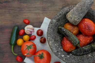 Photo of Ingredients for tasty salsa sauce, pestle and mortar on wooden table, flat lay