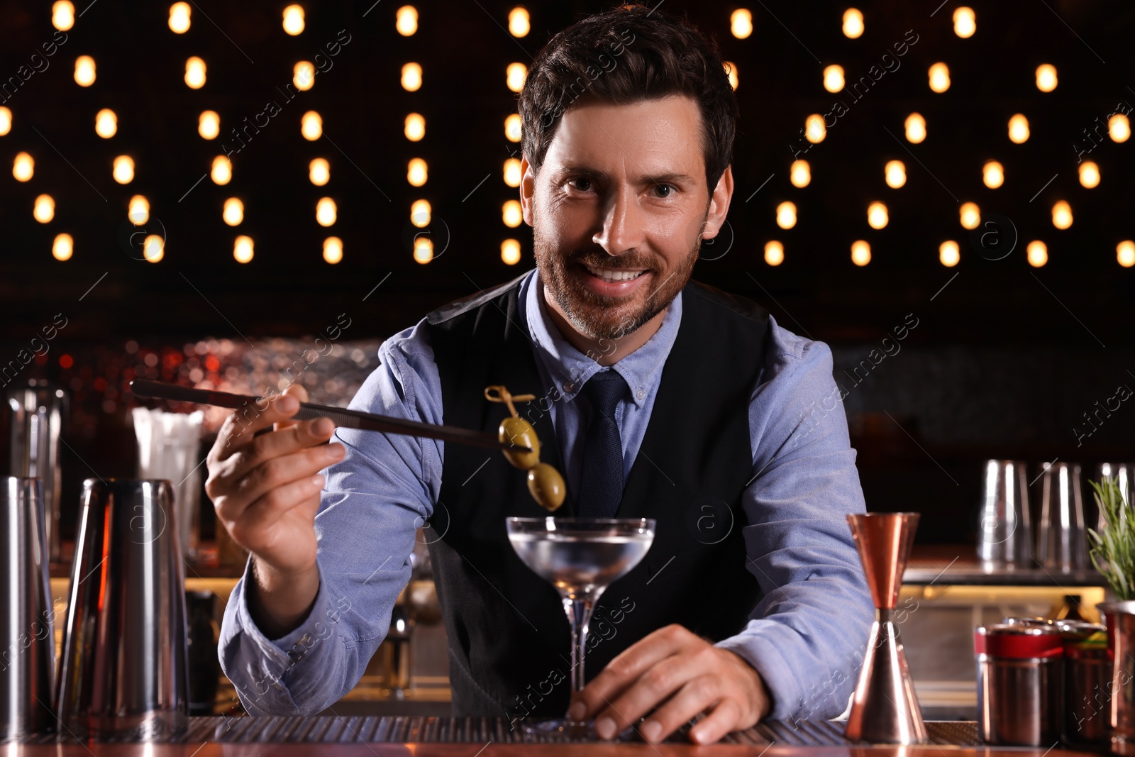 Photo of Bartender preparing fresh alcoholic cocktail in bar