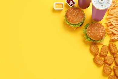 Photo of Flat lay composition with delicious fast food menu on yellow background. Space for text