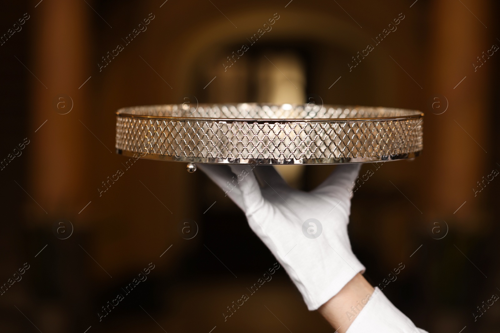 Photo of Butler holding empty tray in restaurant, closeup