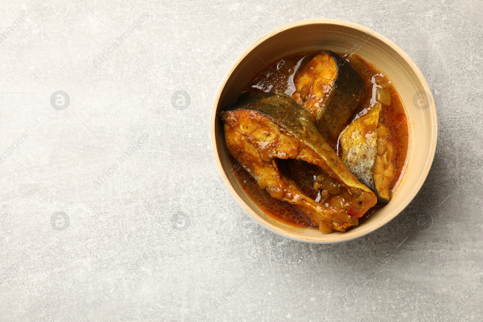 Photo of Tasty fish curry on light grey table, top view. Space for text. Indian cuisine