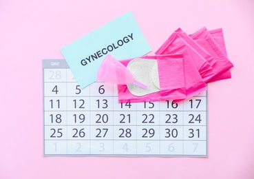 Flat lay composition with calendar and feminine hygiene items on color background. Gynecological care