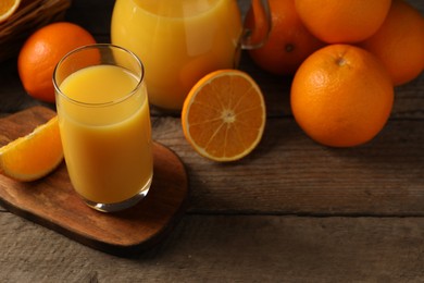 Photo of Tasty fresh oranges and juice on wooden table, closeup