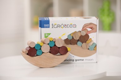 Photo of Wooden pieces of balancing game on white table indoors. Educational toy for motor skills development