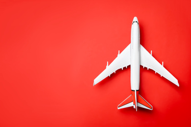 Photo of Top view of toy plane on red background, space for text. Logistics and wholesale concept