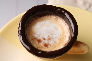 Delicious edible biscuit cup with coffee on plate, closeup