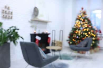 Beautiful Christmas tree near fireplace and cosy armchairs in room, blurred view