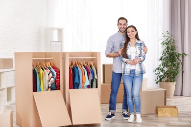 Photo of Young couple near wardrobe boxes at home