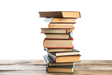 Stack of old vintage books on wooden table against white background