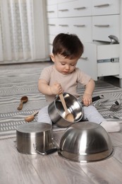 Photo of Cute little boy with cookware at home